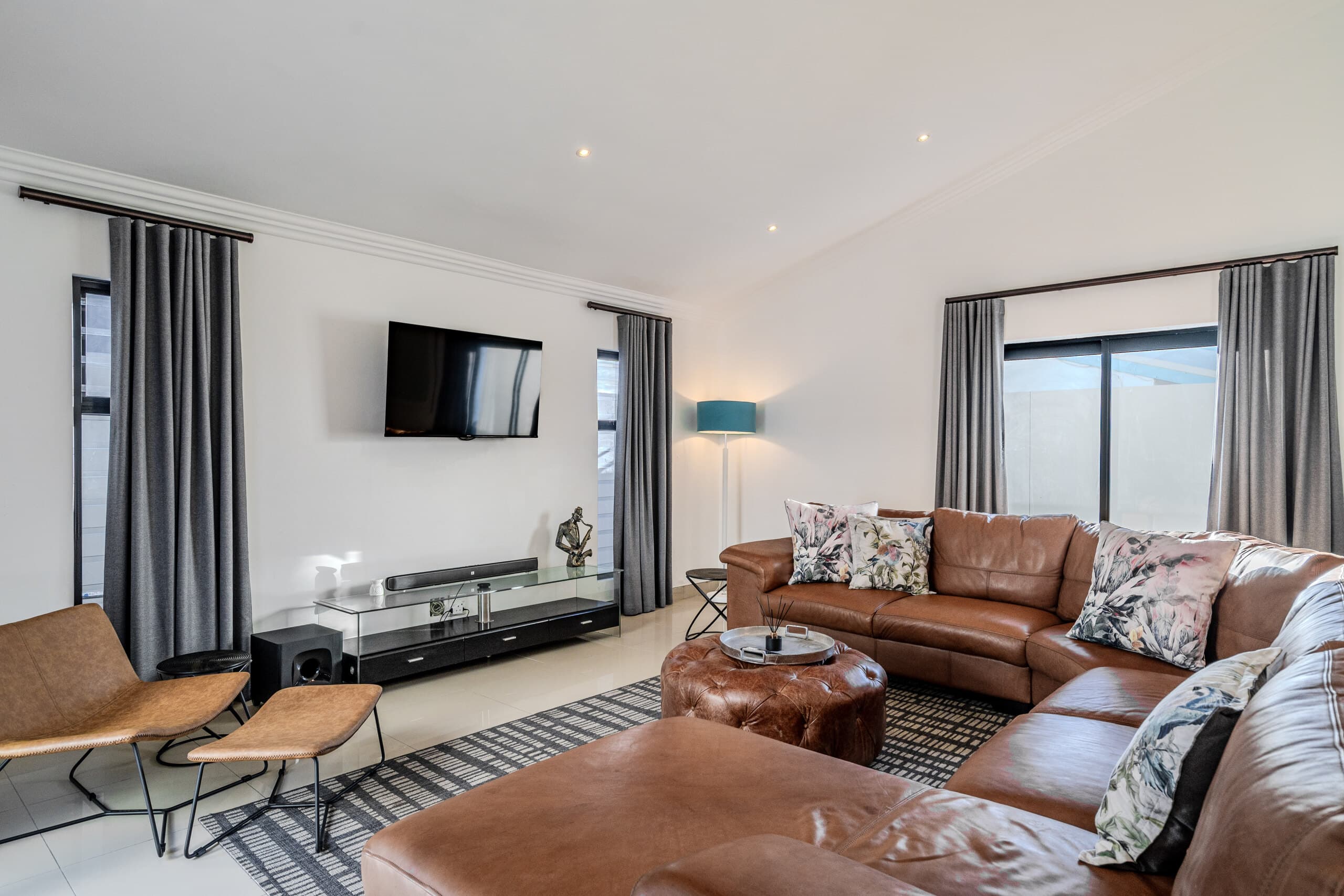 Living room with brown leather sofas and a wall-mounted television