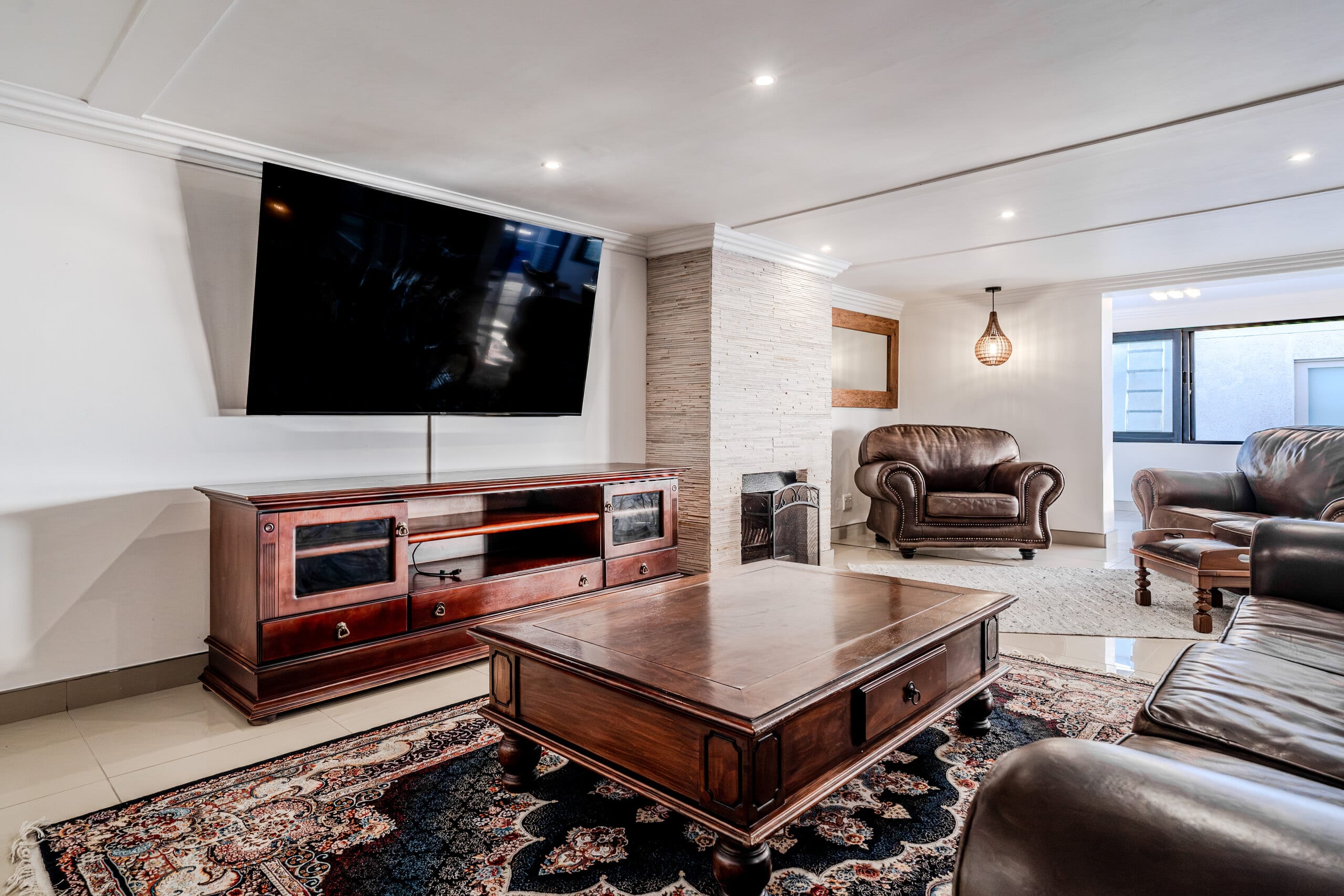 The Lion’s Den at The Lighthouse: leather sofas, layered rugs and a fireplace in a warmly lit lounge